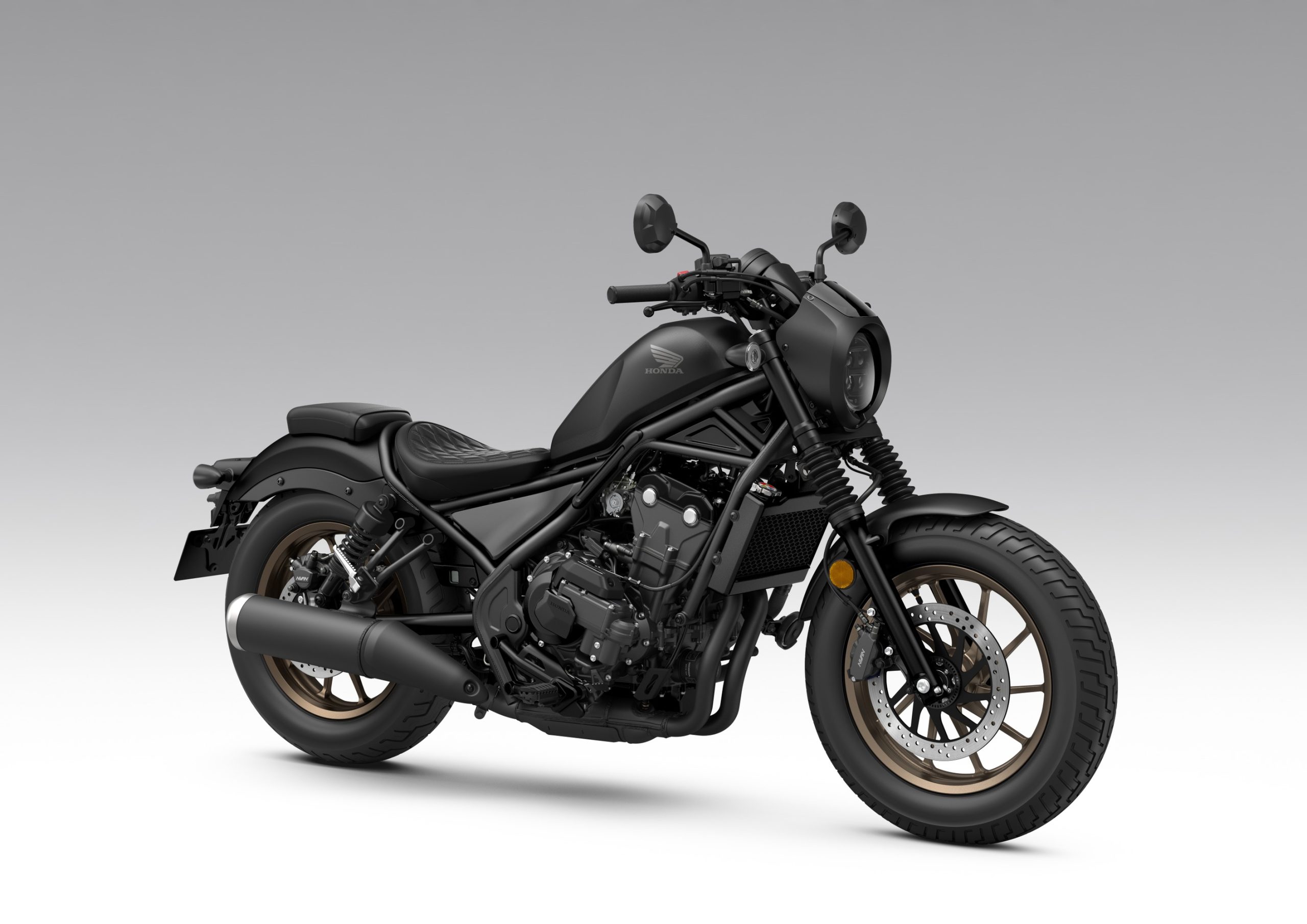 Honda CMX500 Rebel E-Clutch S Edition de 2027 em Mat Gunpowder Black Metallic, com jantes em bronze, a três quartos de frente do lado direito, em estúdio.