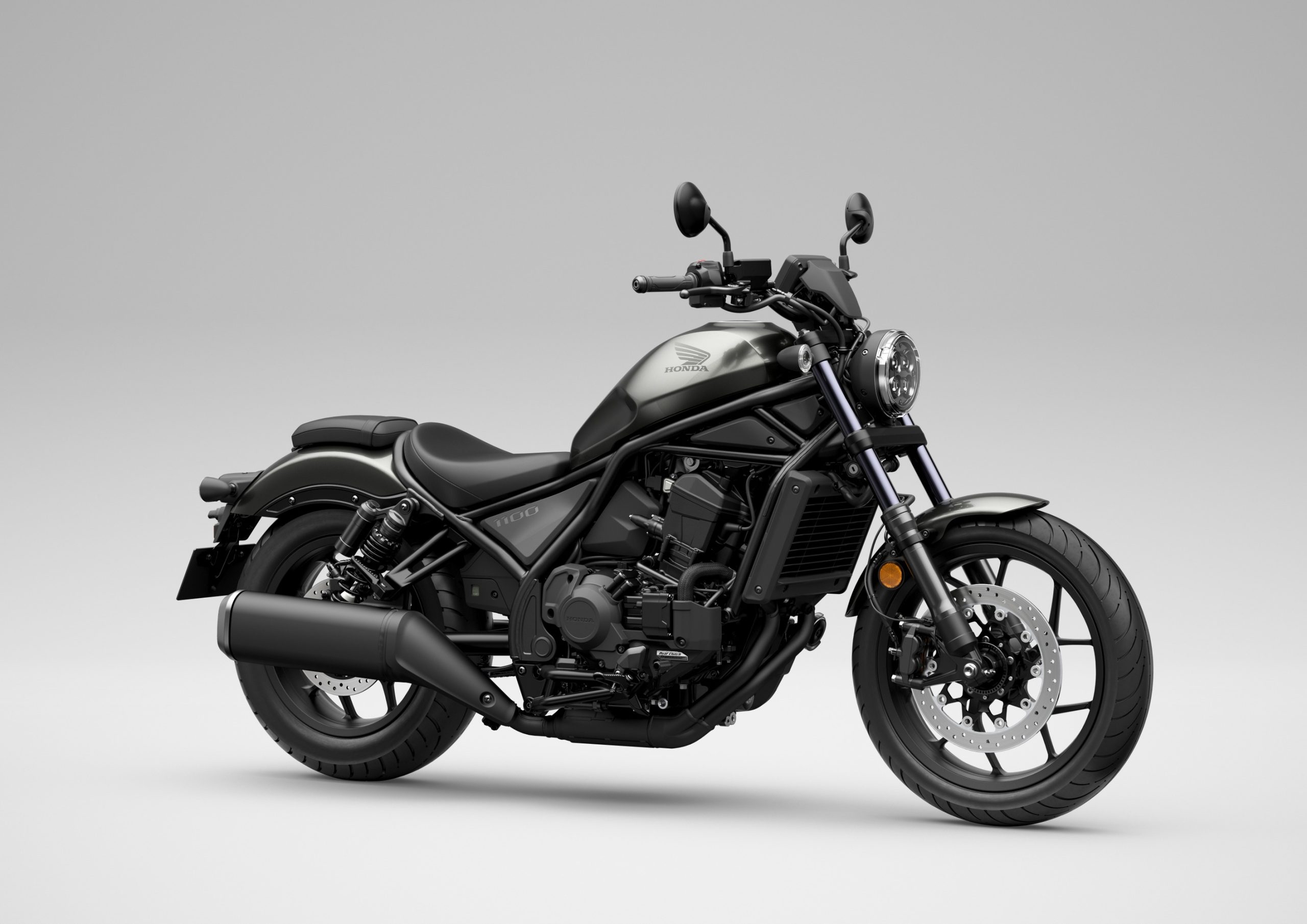 Honda CMX1100 Rebel de 2027 com caixa DCT, na cor Iridium Gray Metallic, de três quartos de frente, em estúdio.